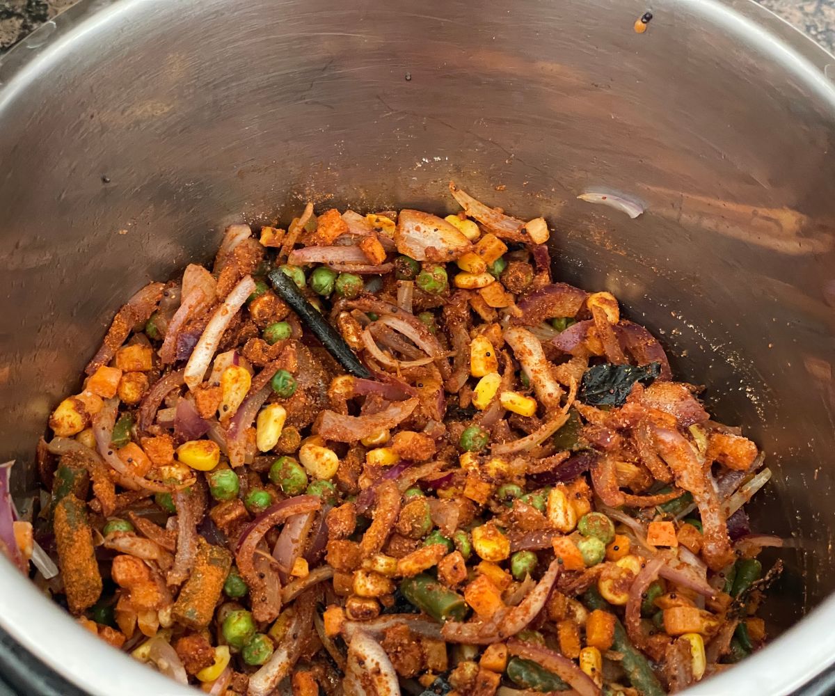 An instant pot has bisisbelebath spices and mixed vegetables.