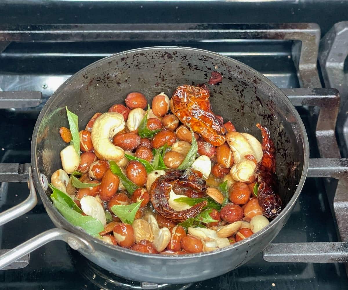 A pan has all the spices, nuts and Curry leaves to season Bisi bele bath. 