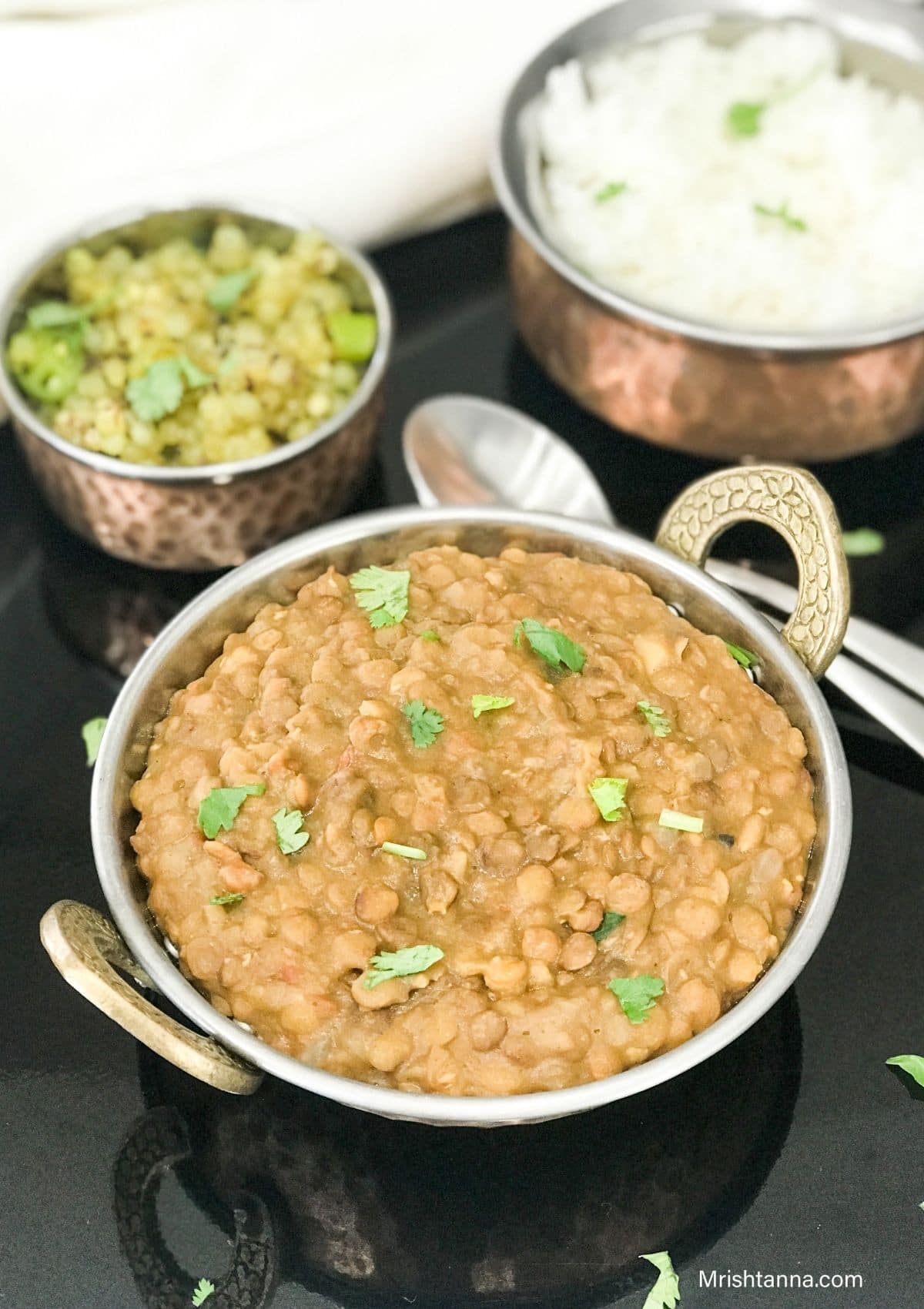 A bowl is filled with lentil curry and topped with cilantro