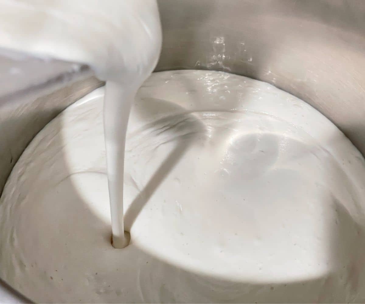 Pouring idli batter inside the big bowl.