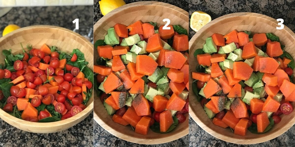 A big bowl of papaya, tomatoes, avocados and spinach blend is on the black surface