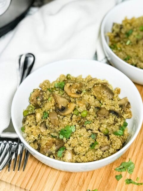 A bowl is filled with mushroom quinoa and topped with cilantro