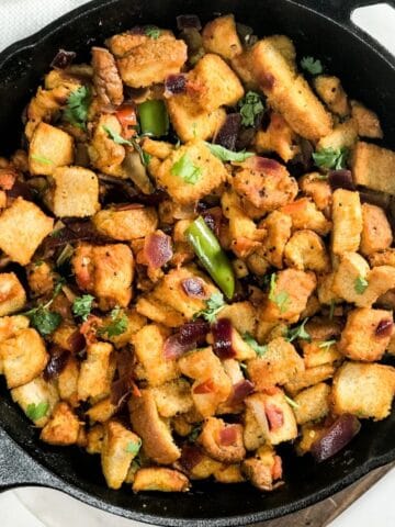 A cast iron pan is with bread upma