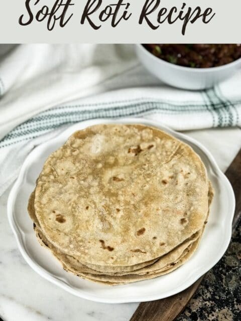 Phulak roti is stacked on the white plate along with side of curry
