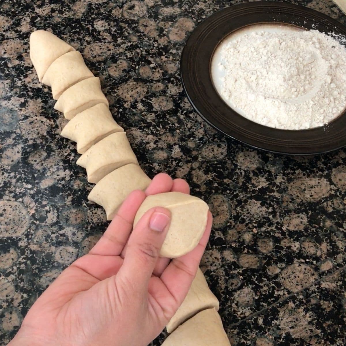 A ball of roti dough is holding by a women