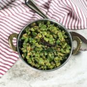 A bowl is with beans palya and its placed on the table