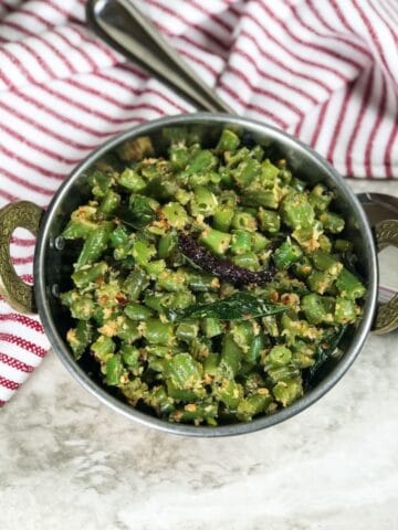 A bowl is with beans palya and its placed on the table