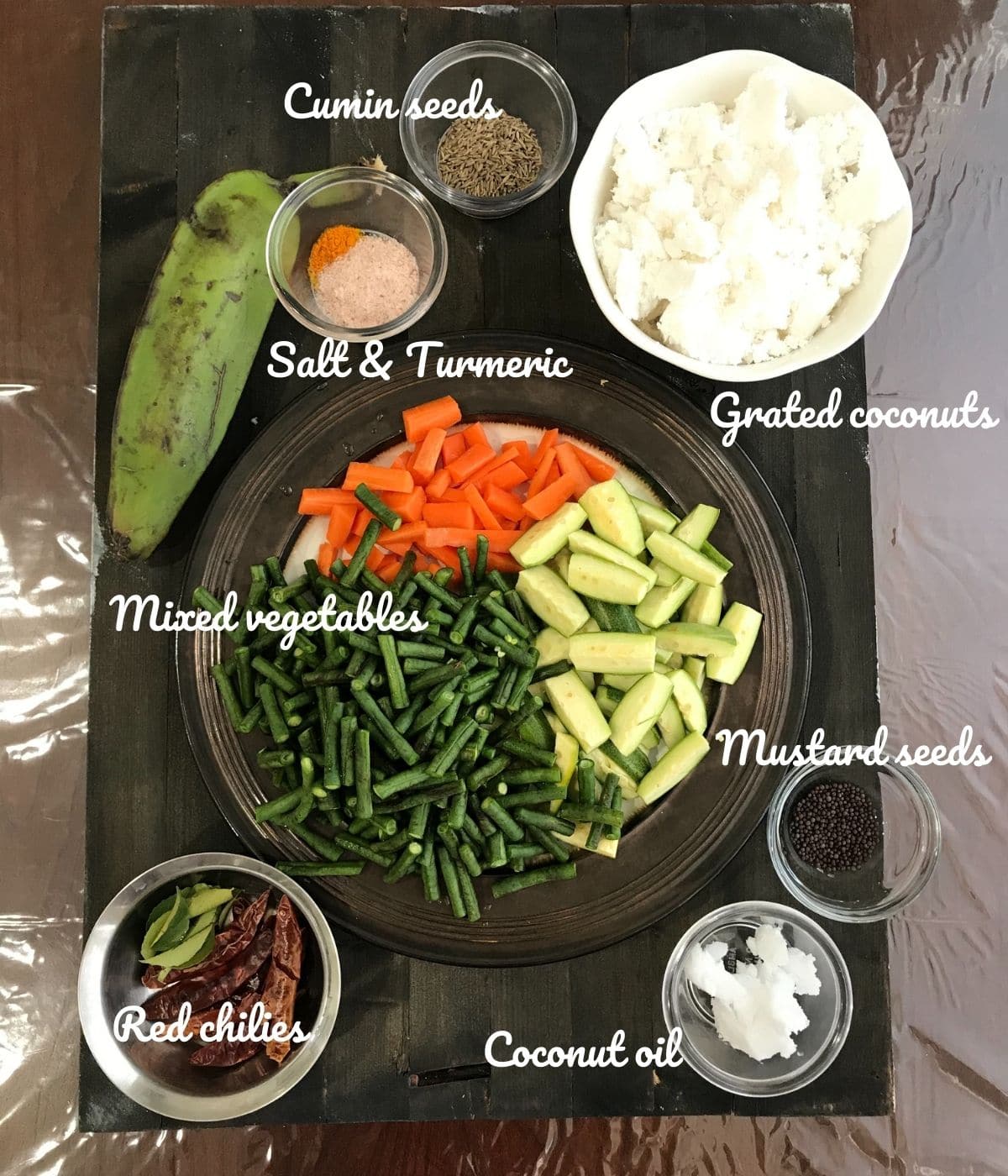 A board is filled with vegetables, spices, and grated coconuts