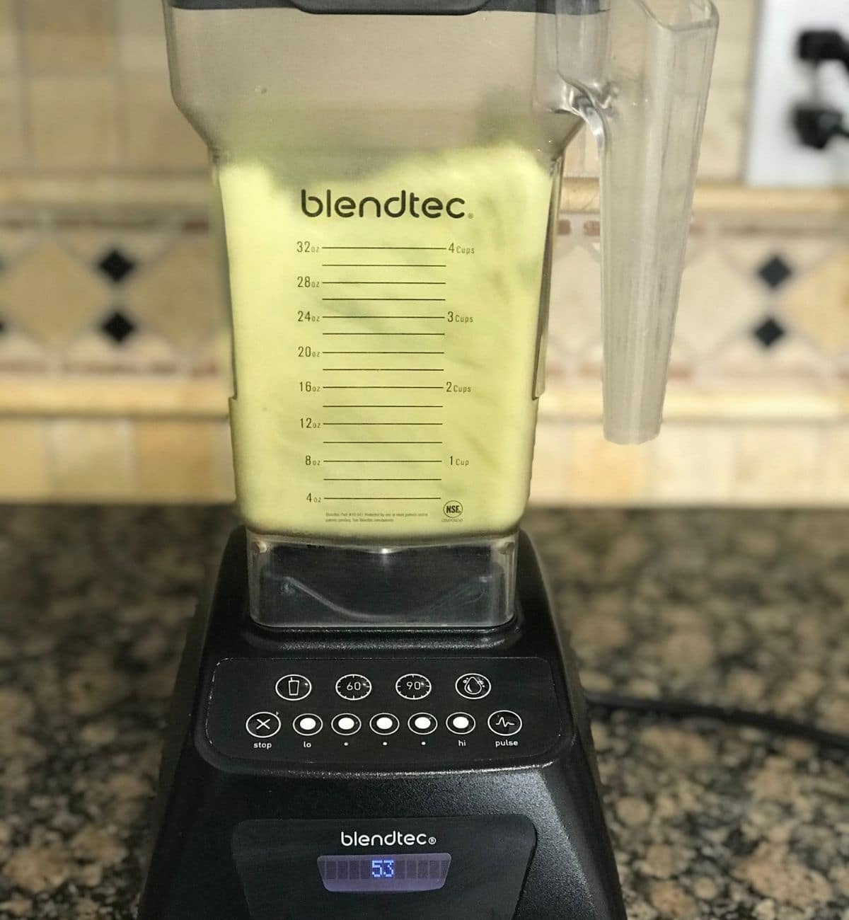 A blender is filled with cucumber smoothie and its over the counter top