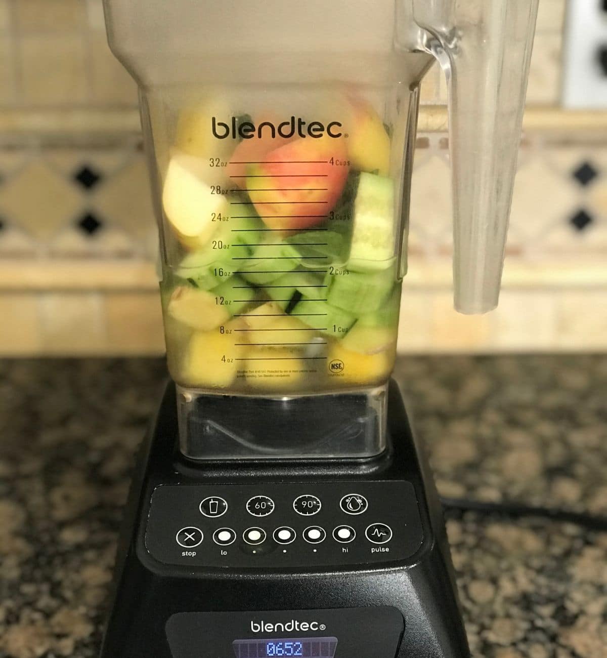 A blender is with cucumber, apple and pineapple for smoothie recipe