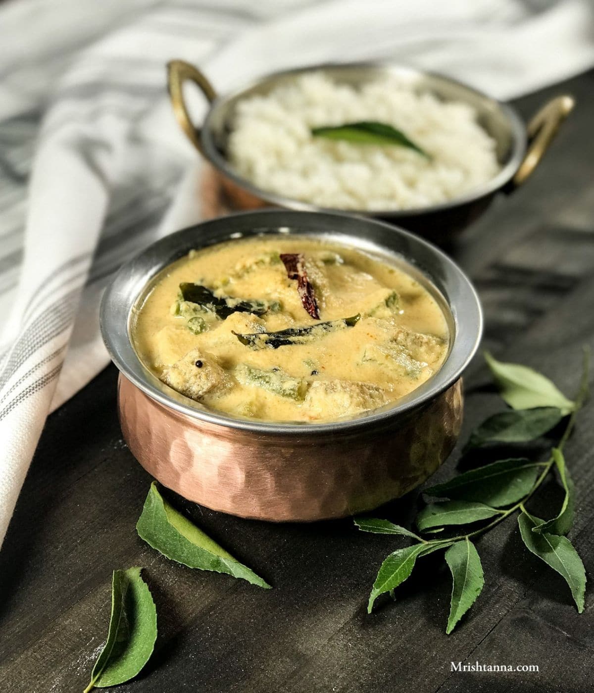 A bowl is filled with avial curry along with white rice