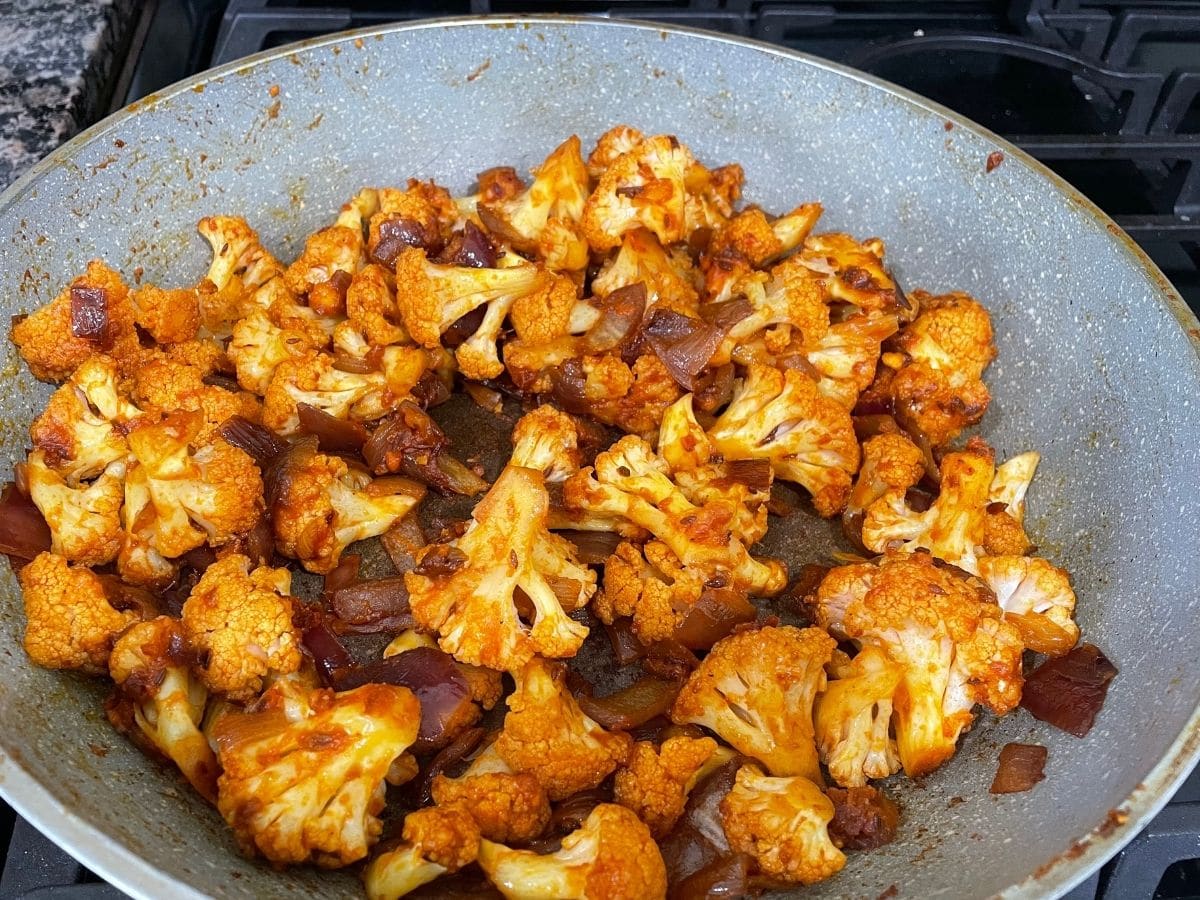 A pan is with cauliflower sabzi over the heat.