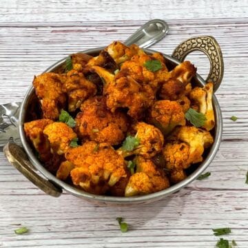 A bowl of cauliflower sabzi is on the white table