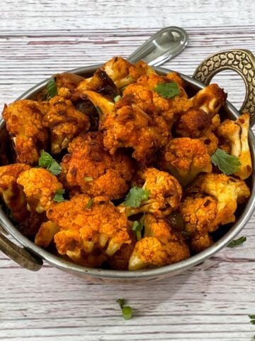 A bowl of cauliflower sabzi is on the white table