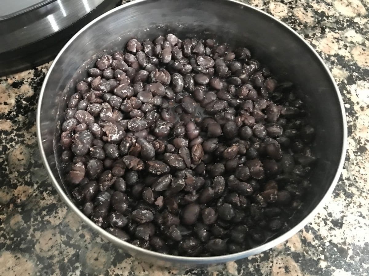 A pot is with cooked black bean on the table