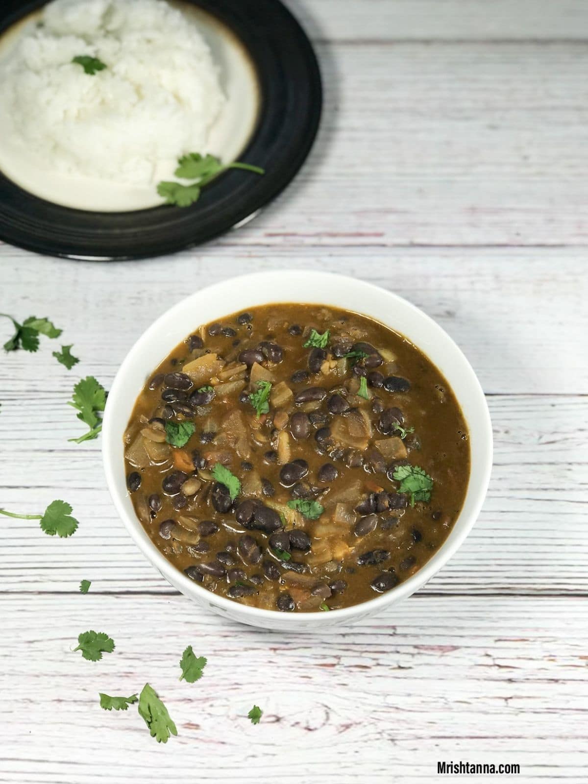 A bowl is filled with black bean curry on the table