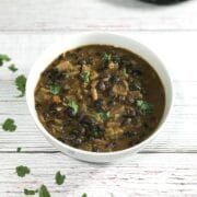 A bowl of black bean curry is on the table