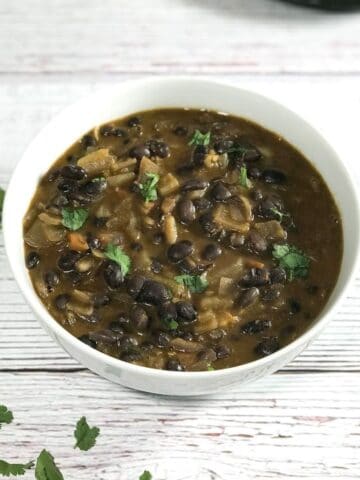 A bowl of black bean curry is on the table