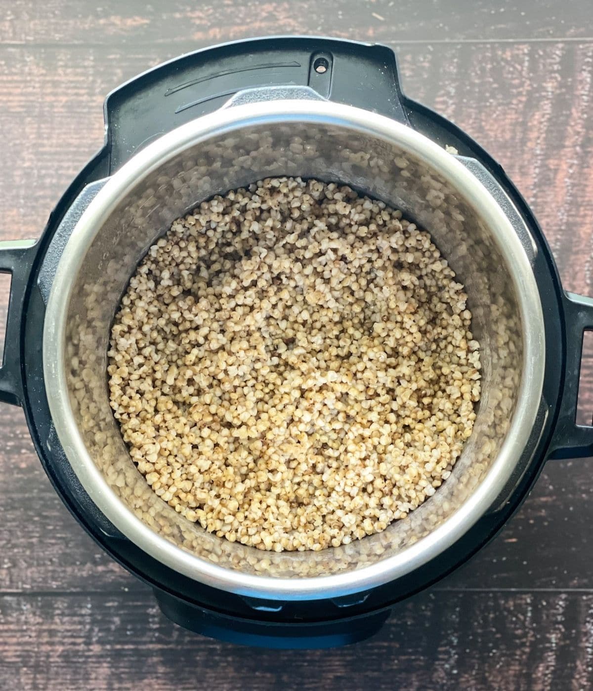 An instant pot is filled with cooked sorghum millet