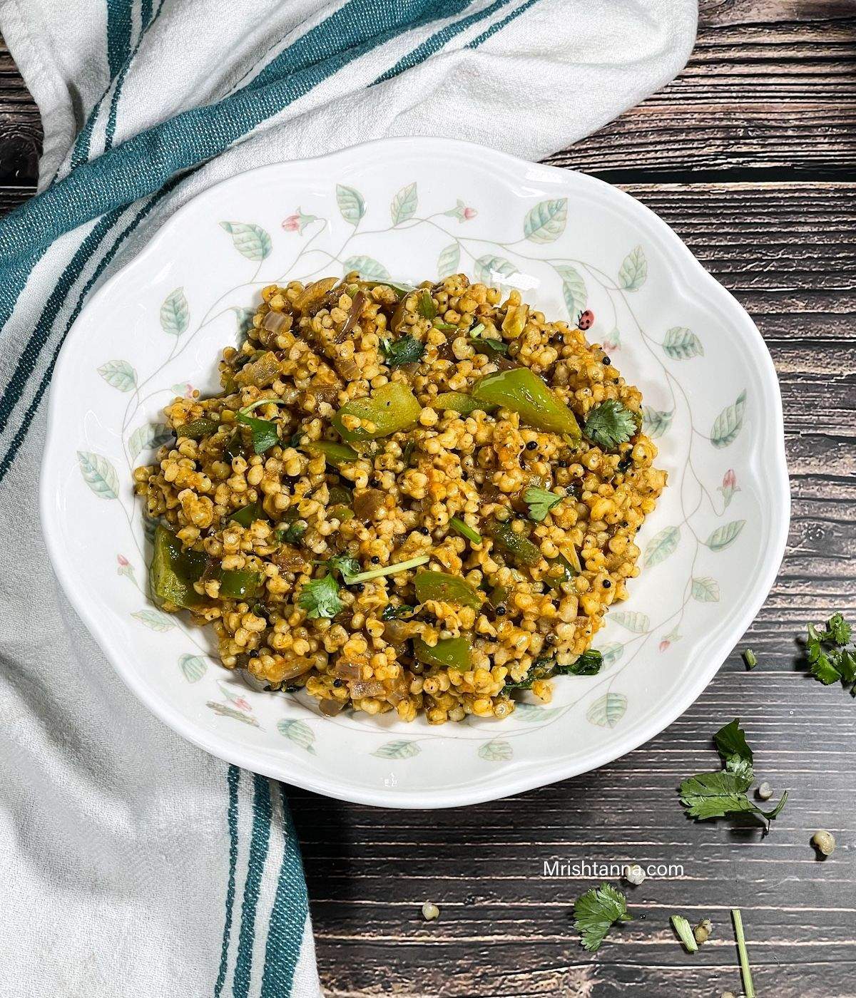 A white plate is filled with jowar upma and its on the table