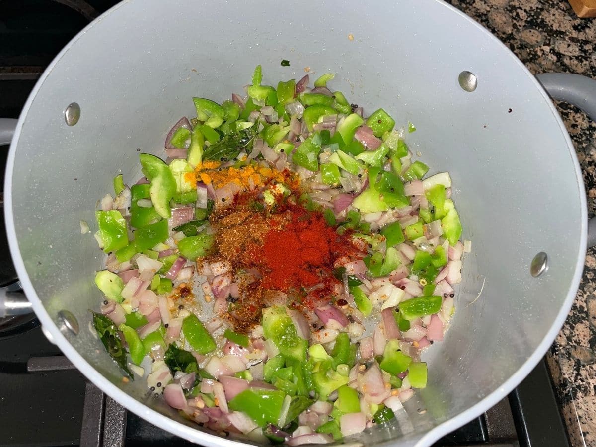 A pot is with spices and vegetables over the heat