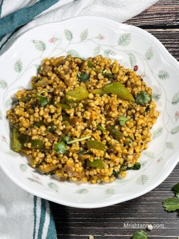 A plate is filled with sorghum upma placed on the table