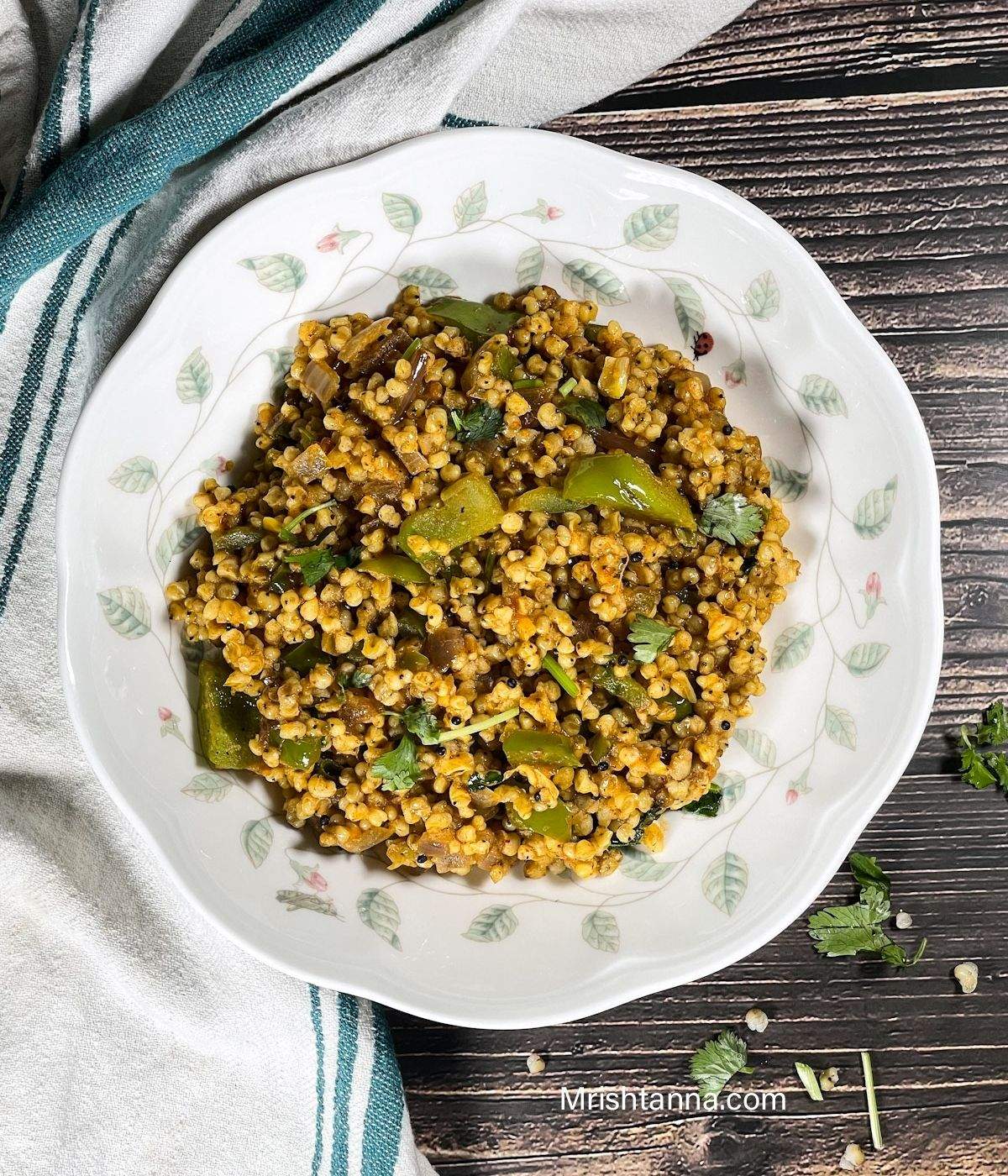 A plate is with jowar upma and topped with cilantro 