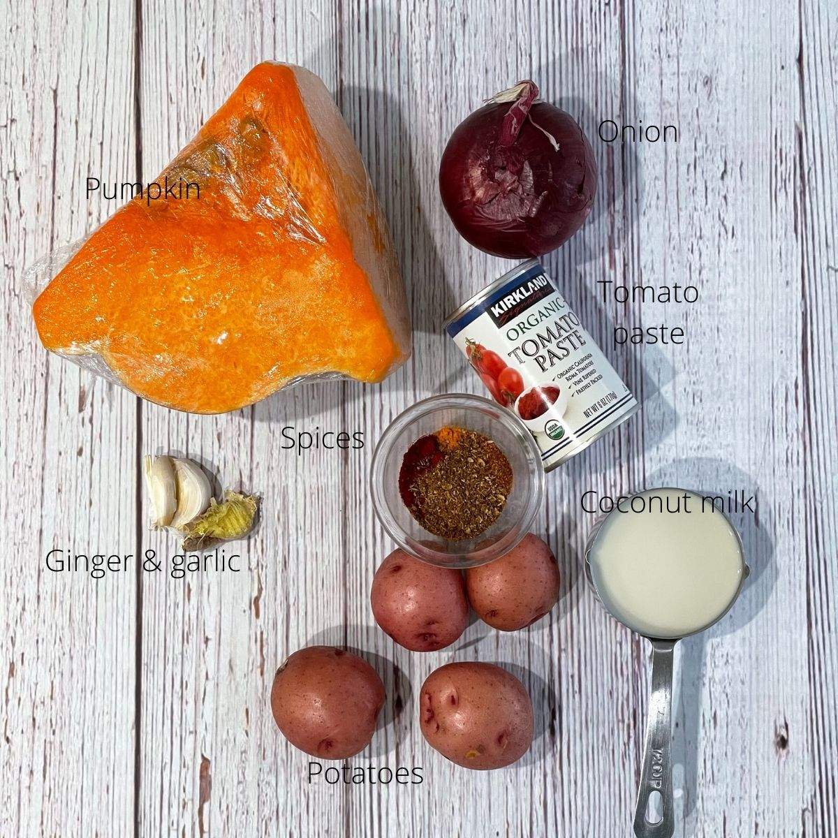 On the table all the ingredients for pumpkin are laid like pumpkins, onions, spices and coconut milk.