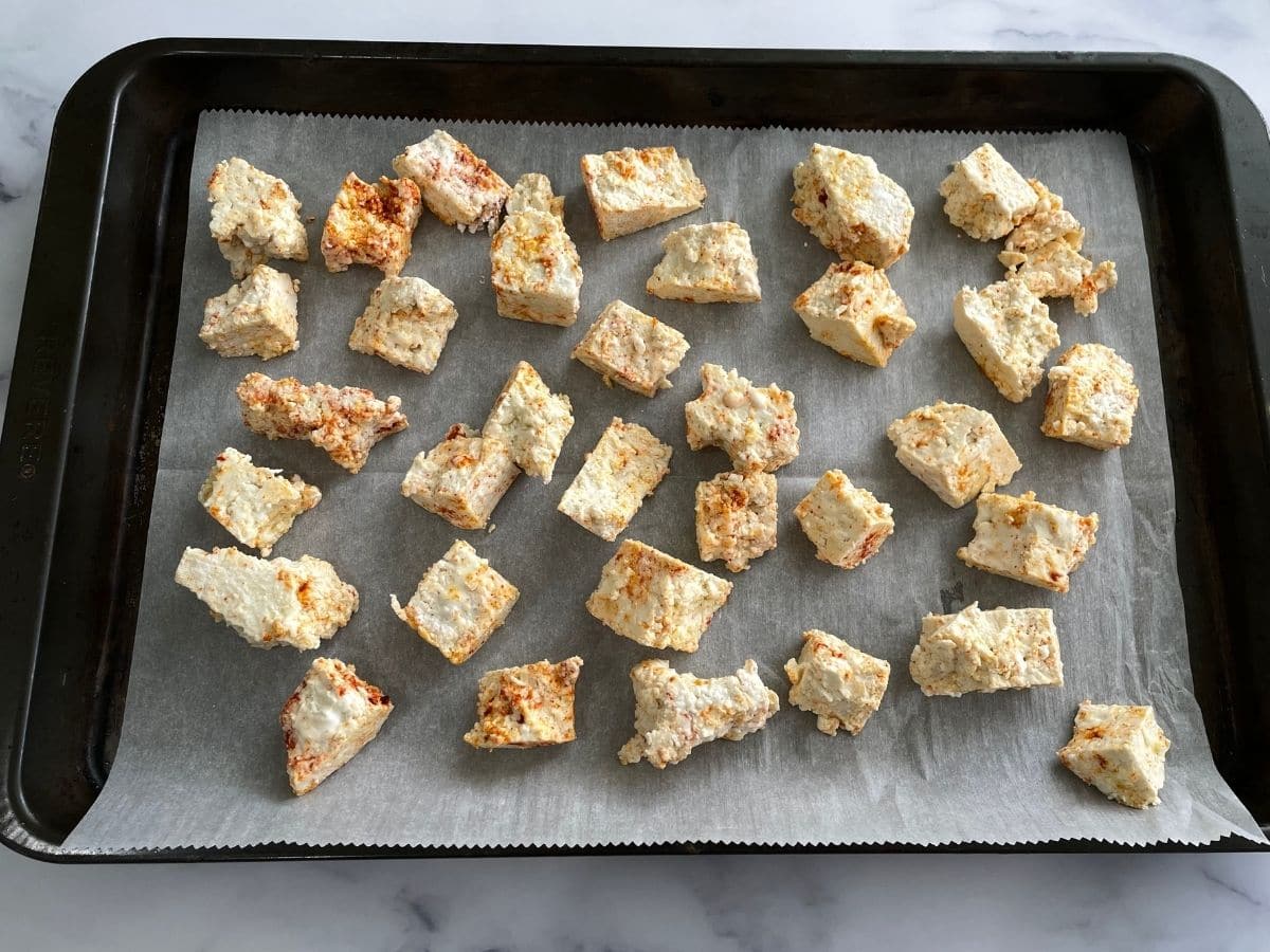 A baking tray is with tofu chunks 