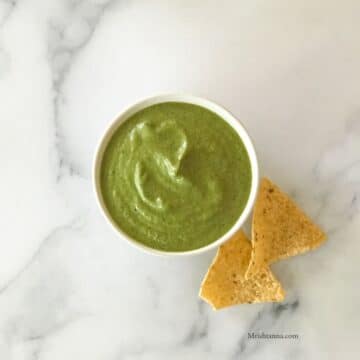 A bowl of jalapeno salsa is on the white table