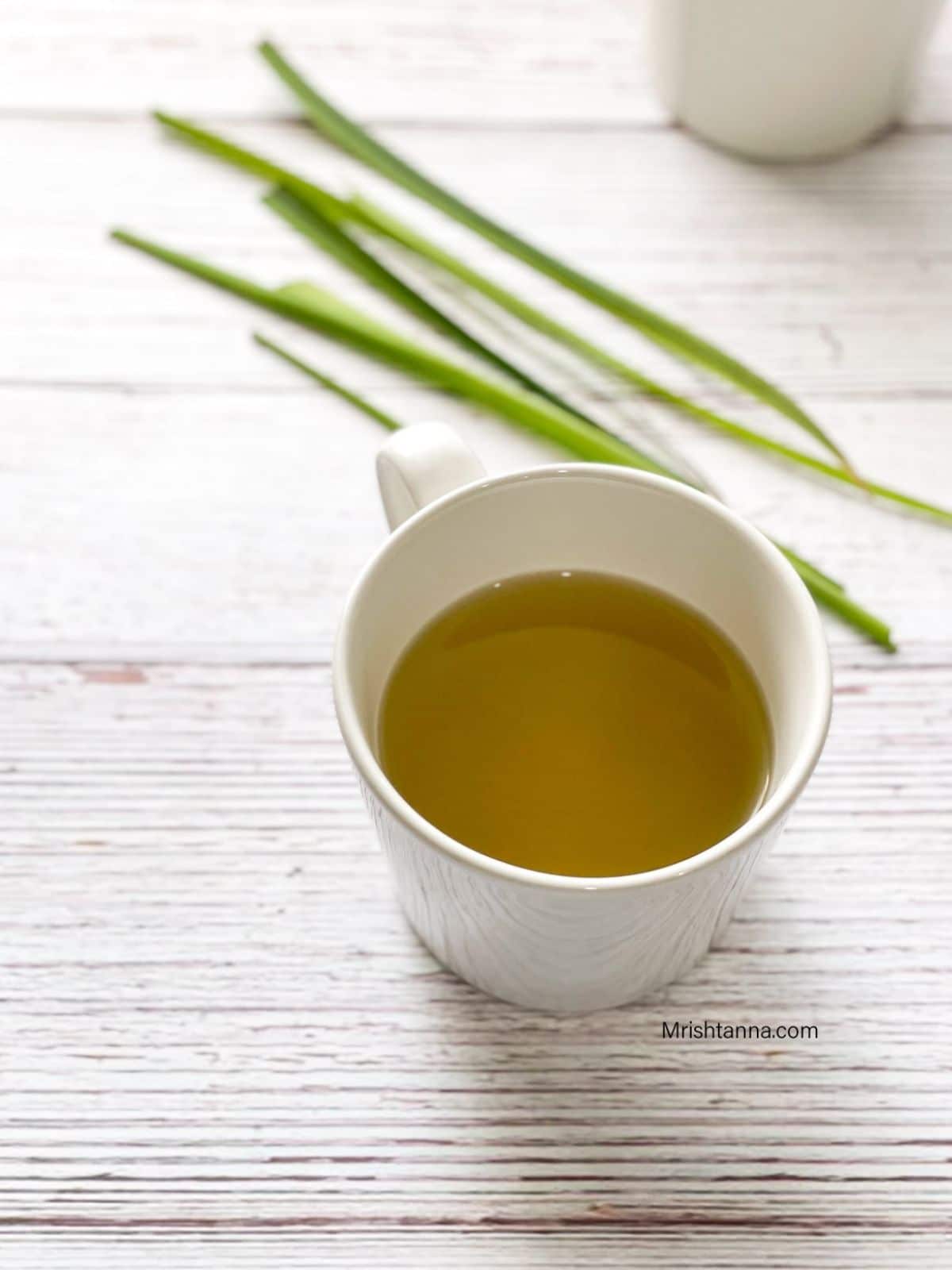 A cup of lemongrass tea is on the table