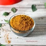 A glass bowl is filled with rasam powder mix.