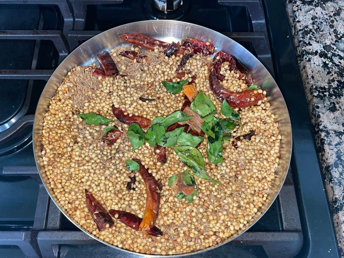 A big plate is with all the roasted spices for rasam powder