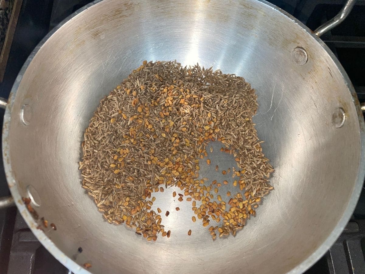 A pan with cumin seeds over the heat for rasam powder