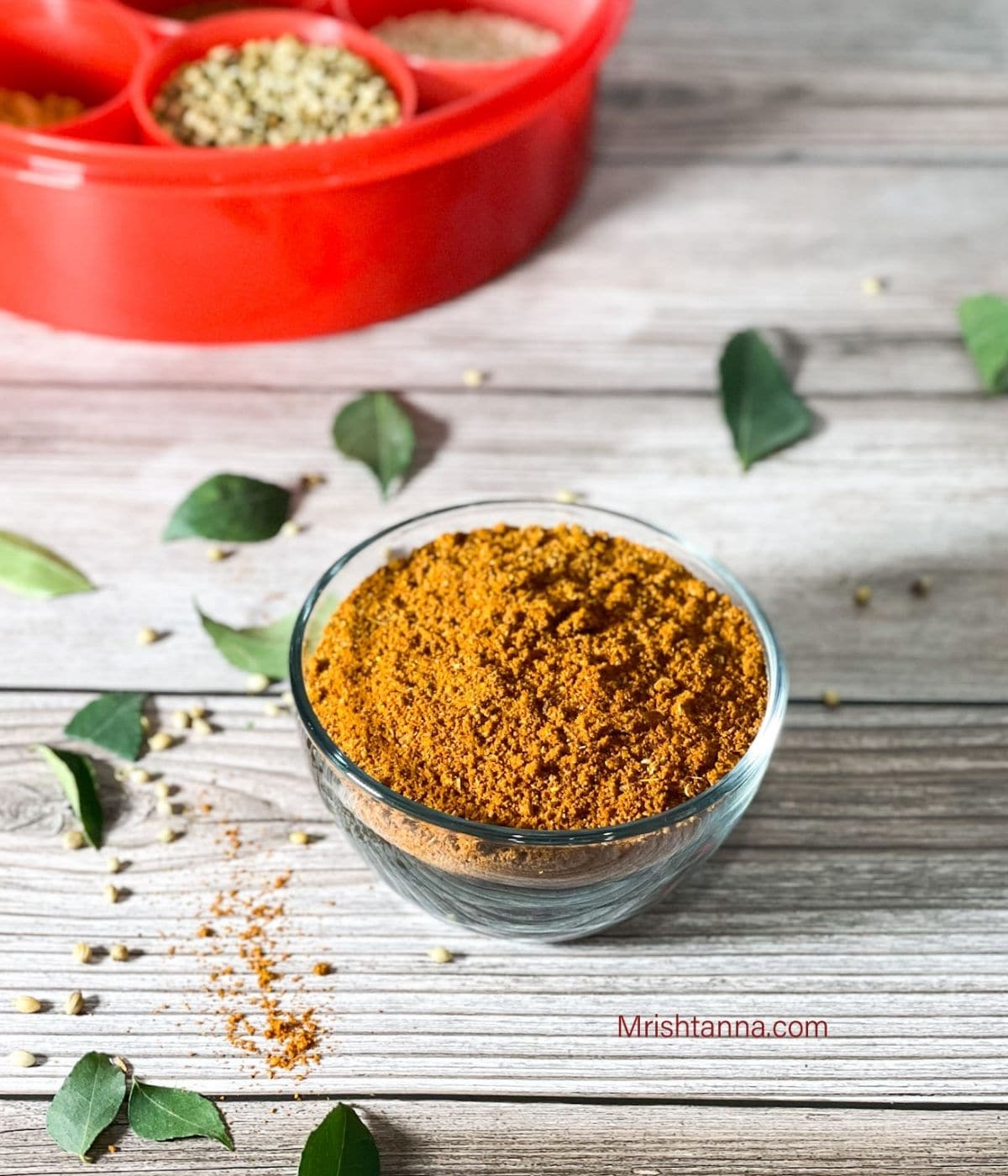 A glass bowl is with rasam powder 