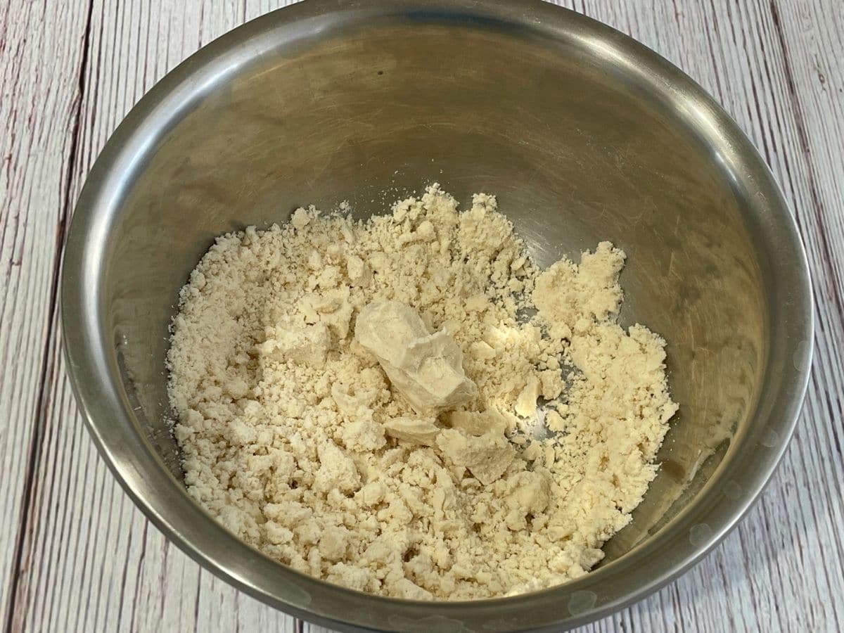 a bowl is with karanji dough on the table.