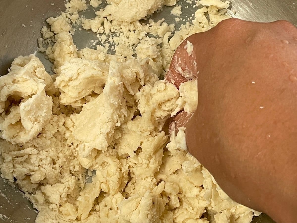 A lady is mixing the karanji dough.