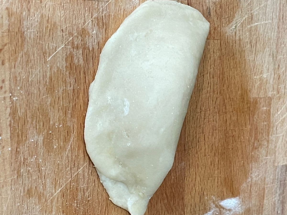 A stuffed and folded karaji dough is on the surface.