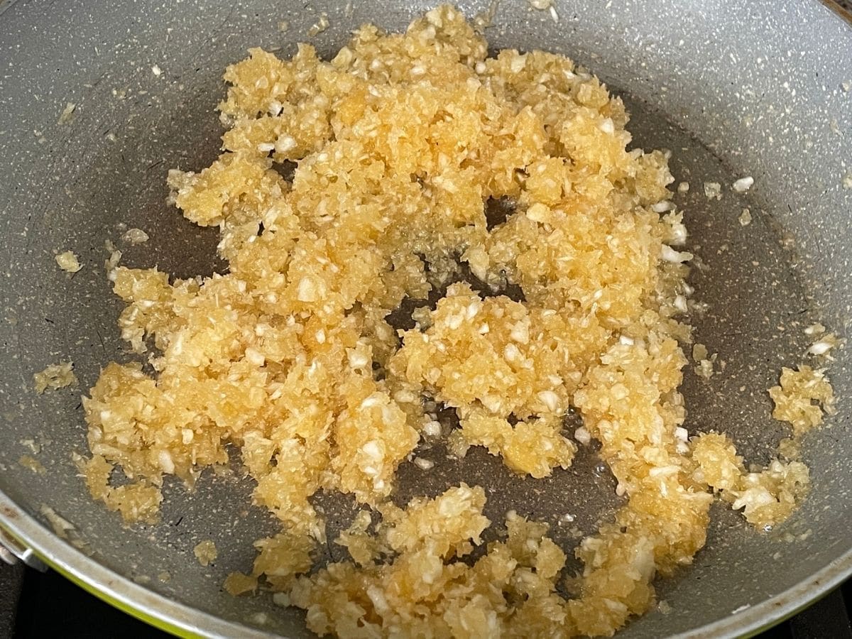 A non stick pan is filled with coconut and jaggery mixture