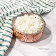 A small pot is filled with Sona masoori rice and placed on the white table.