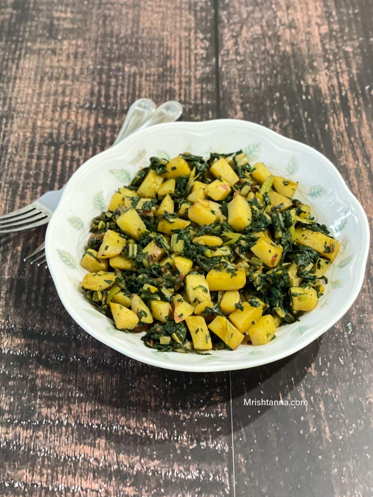 A plate of Swiss chard and potatoes is on the table