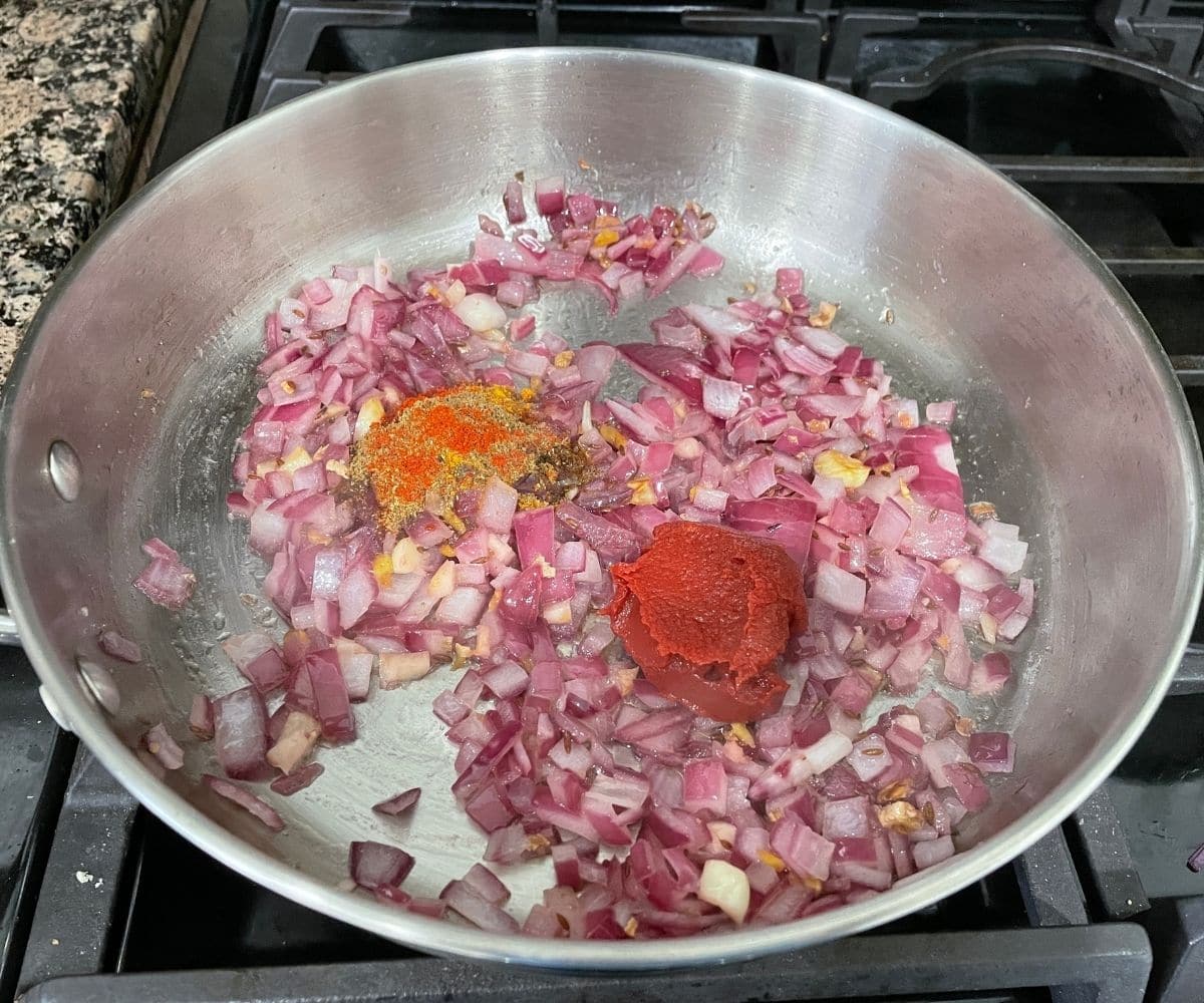 A medium vessel with potato kurma masala over the heat.