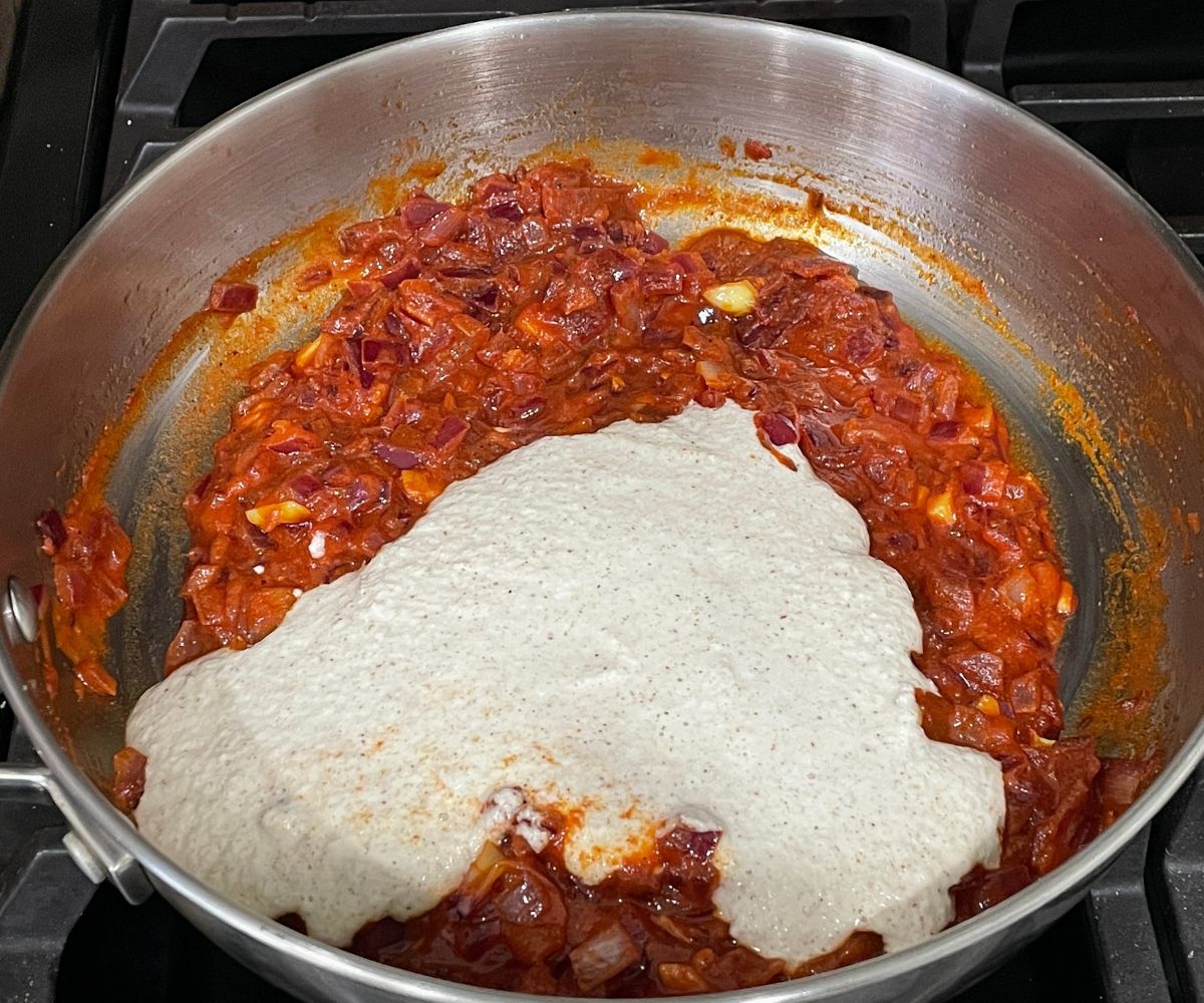 A pan is with aloo kurma masala over the heat.