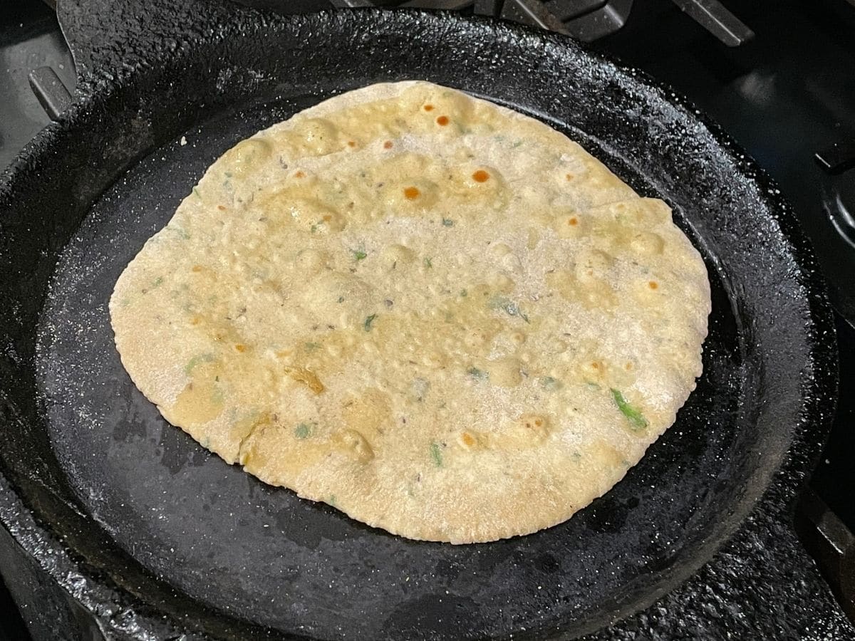 A hot tawa is with cooked besan roti 