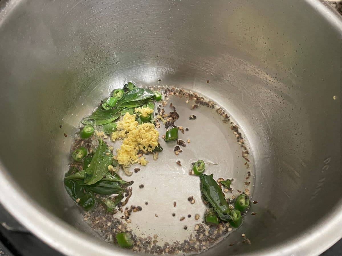 An pot is with spices and ginger for coconut rice.