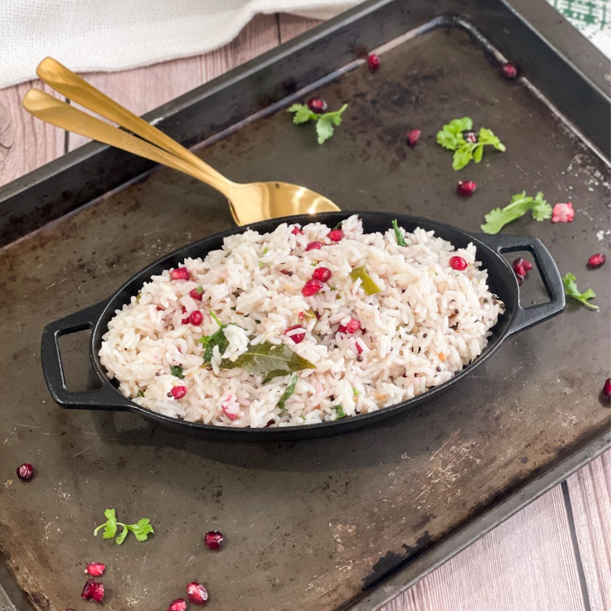 A black pan is with coconut rice and topped with pomegranate
