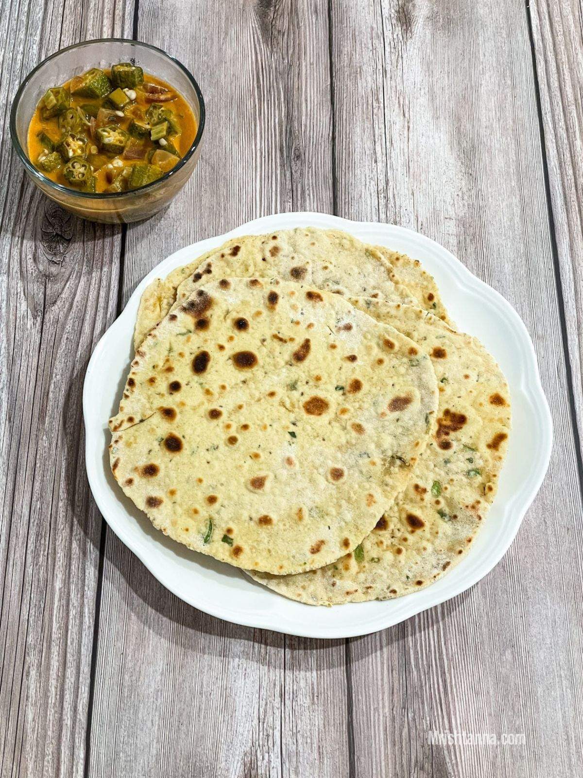 A plate is with besan roti on the wooden table.