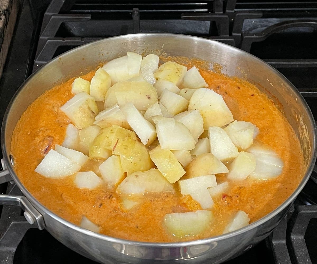 Potato kurma is cooking over medium heat.