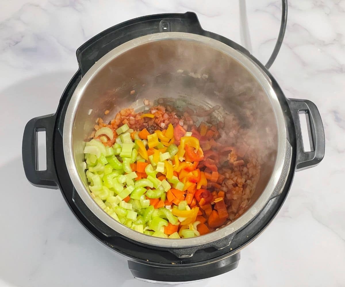 An instant pot with-vegetables for barley soup.
