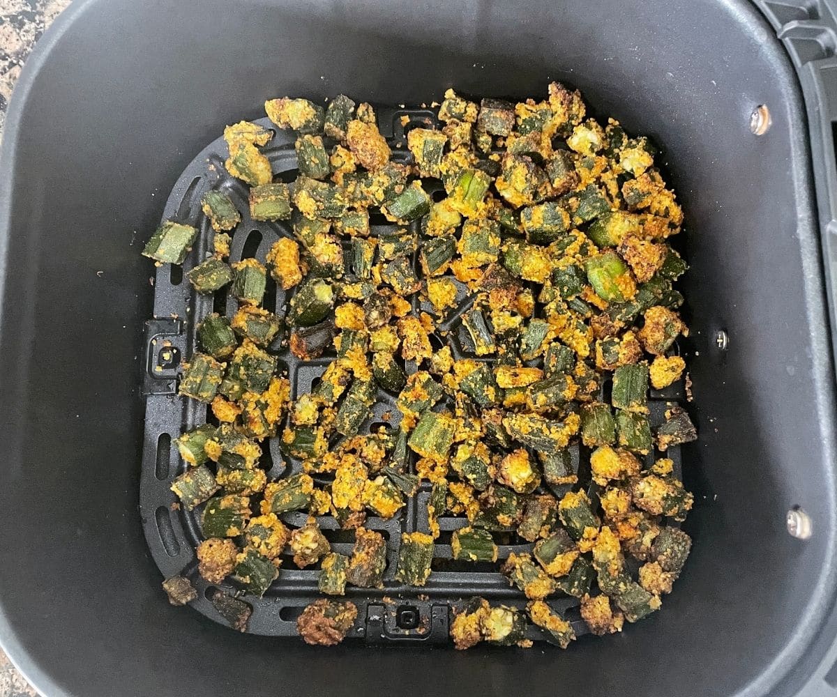 Air fryer basket is with frozen okra.